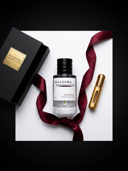A perfume bottle labeled SELLOURA VIOUR ANG ELITE with a black cap, displayed on a white square card with a black box, a gold perfume sample vial, and a dark burgundy ribbon against a black background.