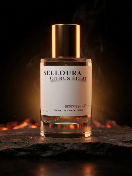 A bottle of Selloura Citrus Eclat perfume stands on a dark stone surface against a black background with warm glowing embers and smoke. The bottle is clear glass with a white label and a metallic gold cap.